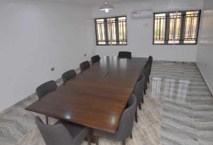 een conferentieruimte met een houten tafel en stoelen bij Room in Lodge - Royal Signature Suites and Apartments in Ibadan