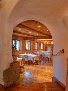 un arco en un comedor con mesas y sillas en Agriturismo Rini, en Bormio