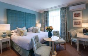 a bedroom with a large bed with a blue headboard at Roslin Beach Hotel in Southend-on-Sea
