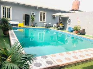 a swimming pool in front of a house at Mayor's & Diplomat Suite in Ikeja