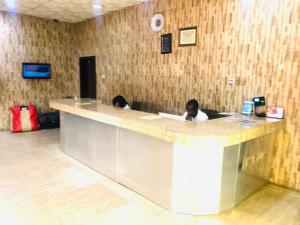 two people sitting at a counter in a room at Mayor's & Diplomat Suite in Ikeja
