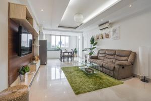 sala de estar con sofá y TV en Alex House Saigon - Serviced Apartment, en Ho Chi Minh