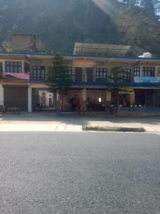 un edificio al lado de una calle con una montaña en Vamoose Srishty Choice, en Rudraprayāg