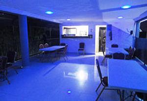 Zimmer mit blauen Lichtern, Tischen und Stühlen in der Unterkunft Room in Lodge - The Beckett Suites in Jabi