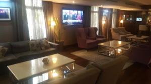 a living room with couches and tables and chairs at Room in Lodge - The Sojourner by Genesis in Ikeja