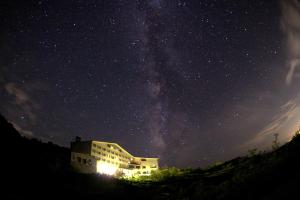 un edificio bajo un cielo estrellado con la Vía Láctea en Midagahara Hotel en Tateyama
