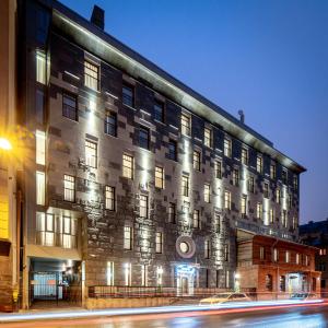 un grand bâtiment avec des lumières sur son côté dans l'établissement Harbor Club Hotel, à Saint-Pétersbourg