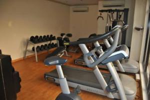 a gym with several exercise machines in a room at Room in Lodge - Waxride Residence Abuja in Jabi