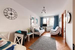 a living room with a clock on the wall at Apartamenty Puerto i Costa blisko plaży w Kołobrzegu in Kołobrzeg