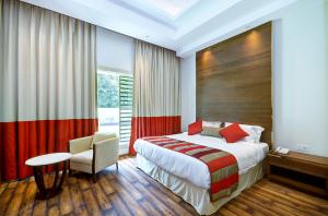 Habitación de hotel con cama y silla en La Sagrita, en Nueva Delhi