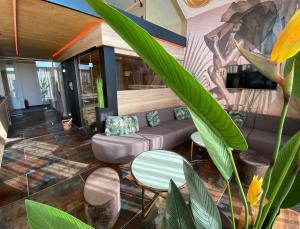 a lobby with a couch and a table and plants at Hotel Leimer Bräu in Lenzing
