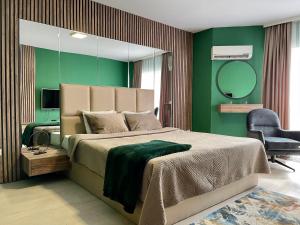 a bedroom with a large bed and a mirror at Downtown Apartments in Prishtinë