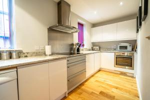 a kitchen with white cabinets and a wooden floor at 15 Stonegate Court in York