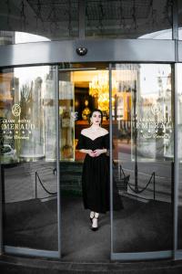Una donna in piedi davanti alla vetrina di un negozio di Grand Hotel Emerald a San Pietroburgo