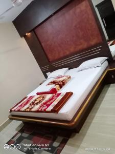 duże łóżko z drewnianym zagłówkiem w pokoju w obiekcie Vamoose Sujata Residency w mieście Sundargarh