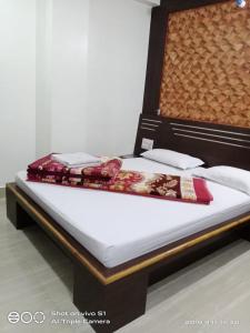 A bed or beds in a room at Vamoose Sujata Residency