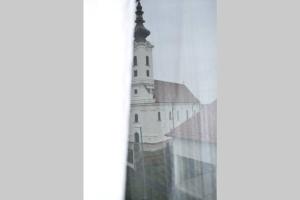 - une vue sur une église depuis une fenêtre dans l'établissement Apartman WALKOW, à Vukovar