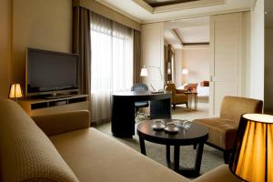 a hotel room with a couch and a television at ANA Crowne Plaza Kanazawa, an IHG Hotel in Kanazawa