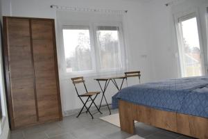 a bedroom with a bed and a table and two chairs at Apartman WALKOW in Vukovar