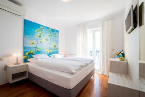 Un dormitorio con una cama grande con un cuadro en la pared. en Rooms Raič, en Dubrovnik