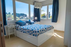 ノート・マリーナにあるVilla Tra Mare e Uliviのベッドルーム1室(青い掛け布団、窓付)