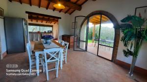 a kitchen and dining room with a table and chairs at Villa Lorenzo con wi-fi, aria condizionata, posto auto in Castagneto Carducci