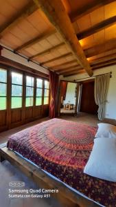 a bedroom with a large bed in a room with windows at Villa Lorenzo con wi-fi, aria condizionata, posto auto in Castagneto Carducci