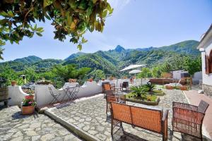 a patio with chairs and a view of mountains at Villa Inn Costa in Tramonti