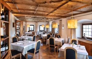 ein Restaurant mit Tischen, Stühlen und Weinflaschen in der Unterkunft Ansitz Fonteklaus in Klausen