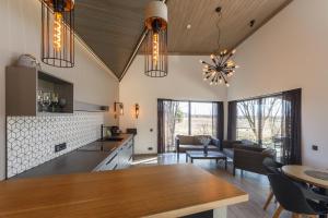 een keuken en een woonkamer met een tafel en stoelen bij Pļavas Holiday House in Ainaži