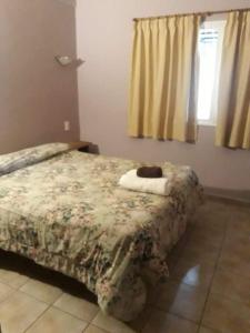 a bedroom with a bed with a comforter on it at Maryfer in Las Grutas