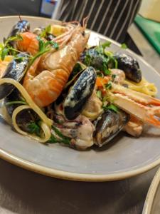 a plate of food with seafood on a table at Port Charlotte Hotel in Port Charlotte