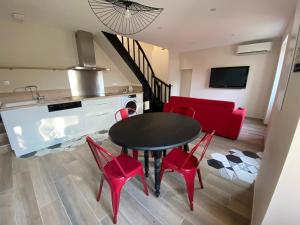 une cuisine et une salle à manger avec une table et des chaises rouges dans l'établissement Le Pavillon de l'Hermitage - Spa ouvert d'Avril à Octobre, à Tain-lʼHermitage