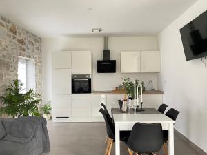 a kitchen and dining room with a white table and chairs at Holiday House Lucia in Sukošan