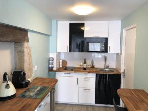 a kitchen with white cabinets and a sink at BlanzayAprtment 1bed Pool Bbq Wifi FreeP in Blanzay