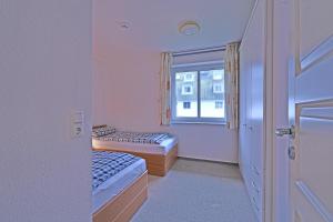 una piccola camera con due letti e una finestra di BER-511-Appartementresidenz a Scharbeutz