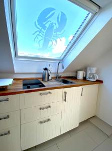 a kitchen with a window with a spider on it at Haus Germania in Helgoland