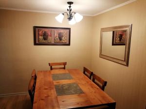 a dining room with a wooden table and chairs at Departamentos amoblados - Santa Sofia. in Concepción