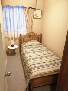 ein kleines Schlafzimmer mit einem Bett und einem Fenster in der Unterkunft Departamentos amoblados - Santa Sofia. in Concepción