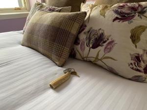 a key on top of a bed next to a pillow at Port Charlotte Hotel in Port Charlotte