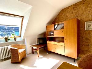a living room with a wooden cabinet and a desk at Haus Germania in Helgoland