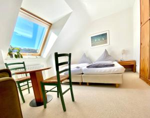 a bedroom with a bed and a desk and a window at Haus Germania in Helgoland