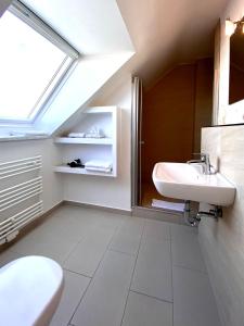 a bathroom with a sink and a toilet and a window at Haus Germania in Helgoland