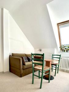 a living room with a couch and a table and chairs at Haus Germania in Helgoland