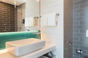 a bathroom with a white sink and a mirror at Holiday Inn Express Amsterdam - North Riverside by IHG in Amsterdam