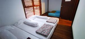 a small room with two beds and a window at Pantai Camara Homestay in Rorahmakan