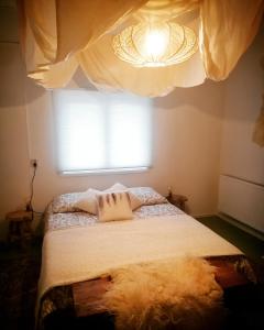 a bedroom with a bed with a window and a chandelier at Logement Doosje in Warfstermolen