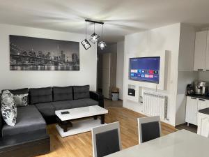 - un salon avec un canapé et une table dans l'établissement Royal Residence Apartmani 2, à Pančevo