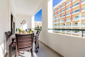 a balcony with a table and chairs and a window at Quinta das Palmeiras Pool & Beach in Pêra in Porches