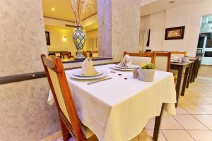 a dining room with a white table and chairs at Hotel Tildi Hotel & Spa in Agadir